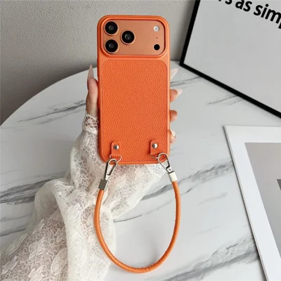 Til iPhone 17 Pro Max Case Metal Paint Litchi-textur PU-læder Telefon Bagdæksel med Håndledrem - Orange