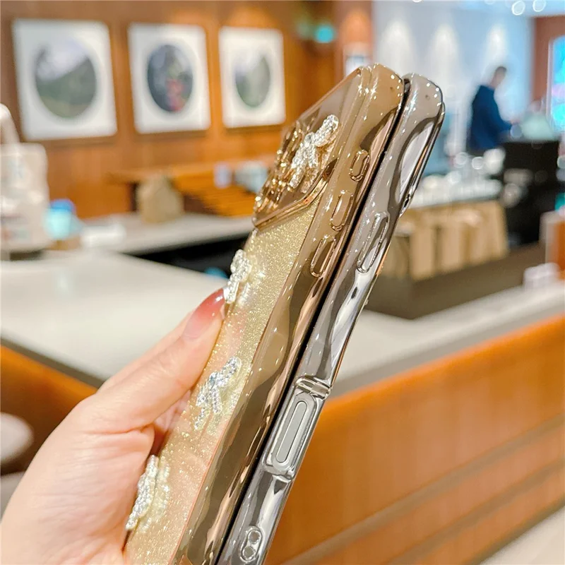 للهاتف iPhone 16 Pro غطاء بتصميم إطار مموج مطلي كهربائياً وغطاء هاتف من مادة TPU متلألئة مع زخرفة رباط من أحجار الراين - أسود