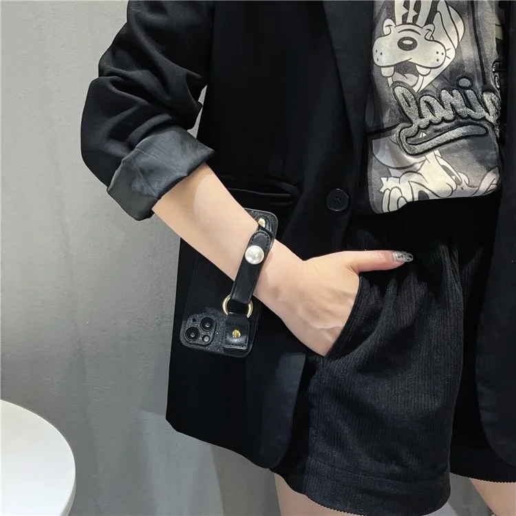 Funda para iPhone 14 a prueba de polvo, con decoración de perlas y correa de muñeca de piel de PU negra + funda de teléfono de TPU