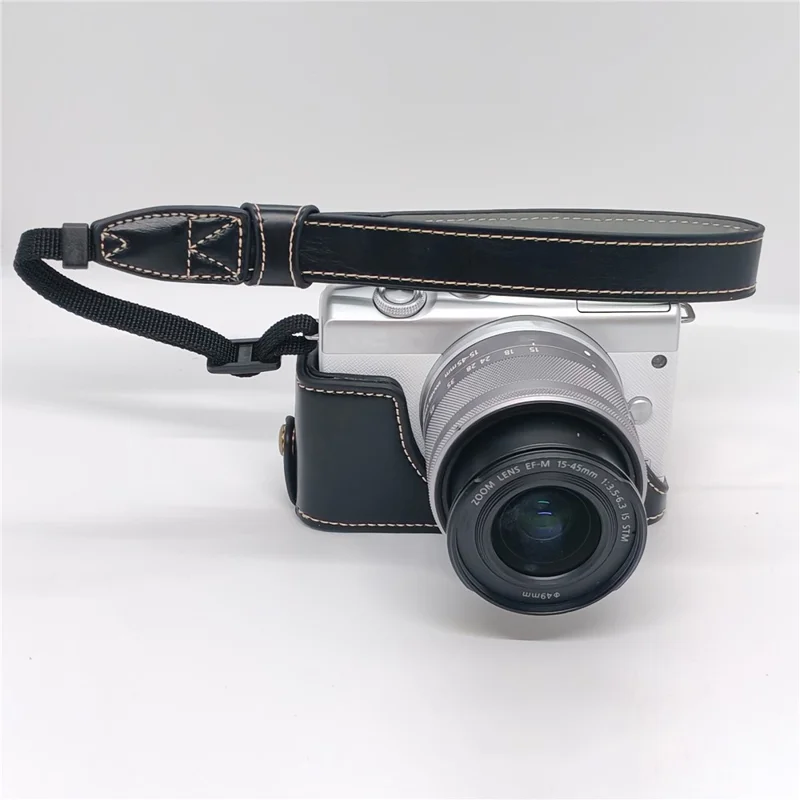 حالة الكاميرا لـ Canon EOS M10 / M100 / M200 غطاء جزئي من الجلد الصناعي مع حزام يد وفتحة قابلة للإزالة لاستبدال البطارية - أسود